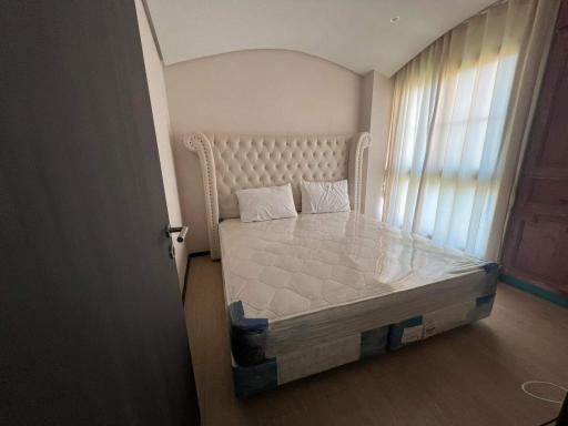 Cozy bedroom with a large tufted headboard and natural light