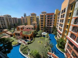 Luxurious apartment complex with central water feature and lush landscaping