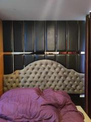 Cozy bedroom with a large tufted headboard and comfortable bedding