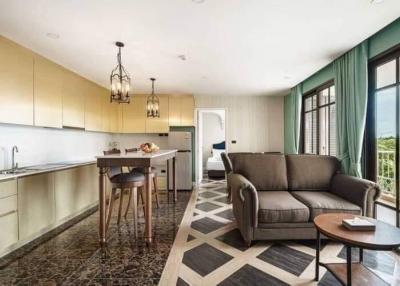 Modern kitchen with adjacent living space featuring marbled flooring, stylish furniture, and ample natural light