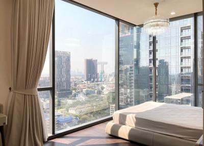 Modern bedroom with a large window offering a city view