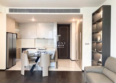 Modern open plan living room with dining area and kitchen in the background