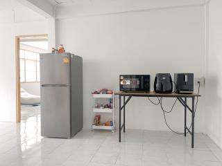 Spacious modern kitchen with appliances and white tiled flooring