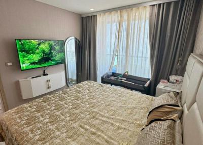 Spacious modern bedroom with large bed and mounted television