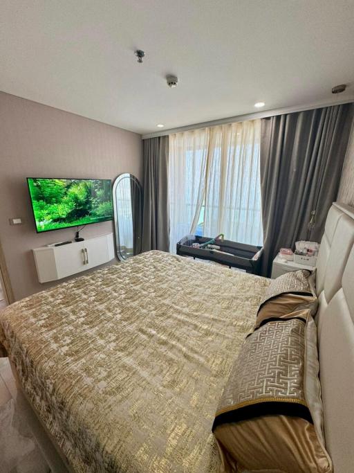 Spacious modern bedroom with large bed and mounted television