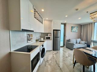 Modern open-plan kitchen with living space, featuring elegant countertops, state-of-the-art appliances, and a comfortable seating area