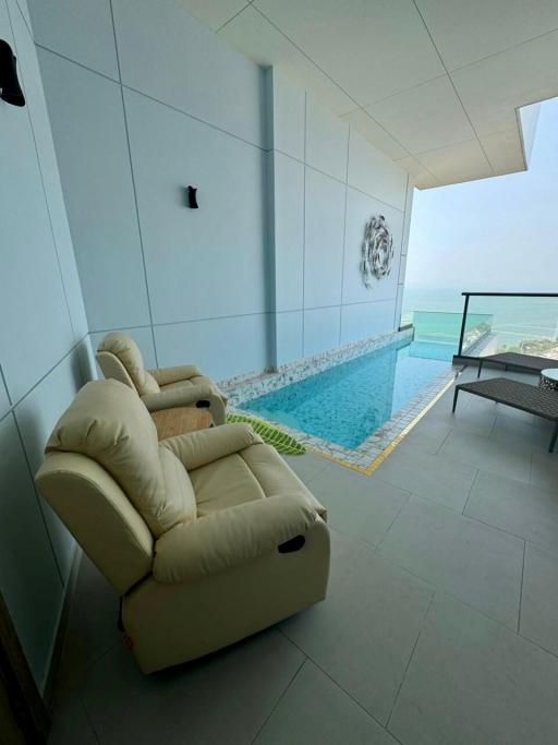 Balcony with a view of the sea, comfortable armchair and private pool