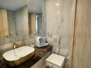 Modern bathroom with wooden cabinets and marble sink