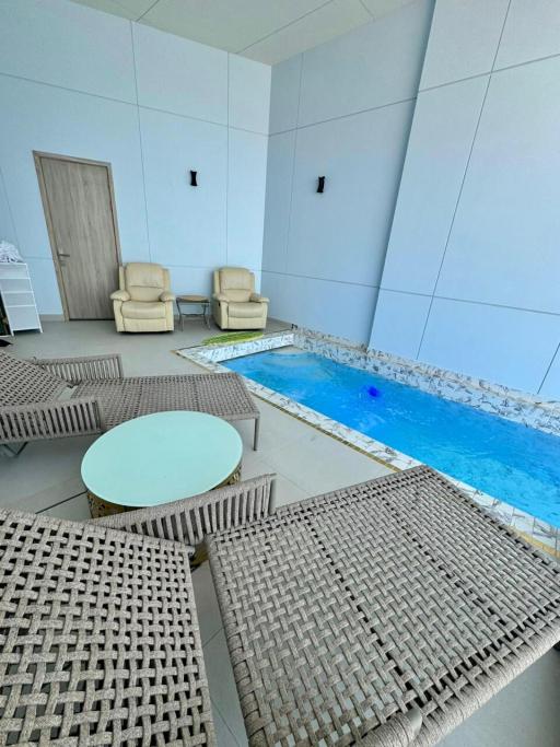 Indoor residential pool area with seating arrangement