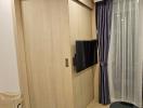 Compact bedroom with modern wardrobe and mounted television