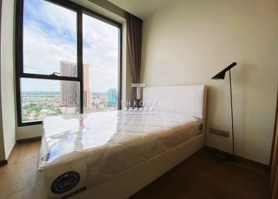 Spacious and well-lit bedroom with large window offering a city view