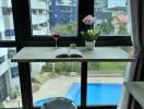 Cozy reading nook with view of pool and cityscape