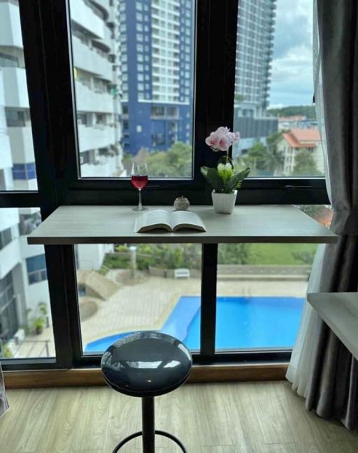 Cozy reading nook with view of pool and cityscape