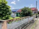 Suburban house exterior with garden and fence under clear skies