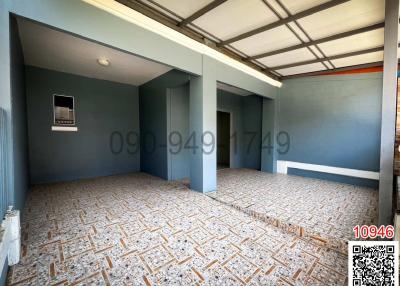 Spacious unfurnished interior of an empty building with tiled flooring and blue walls