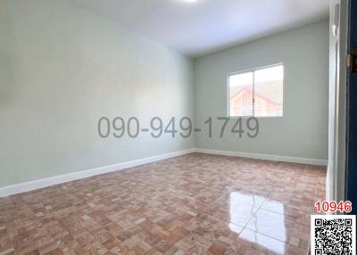 Empty bedroom with parquet flooring and natural light