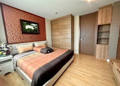 Modern bedroom with wooden flooring and queen-size bed