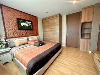 Modern bedroom with wooden flooring and queen-size bed