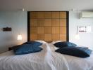 Cozy bedroom with a large bed and modern wooden headboard