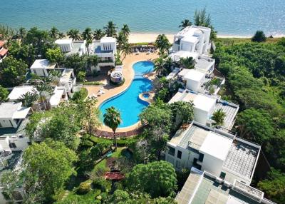 Aerial view of a luxury residential complex with a pool and beach access