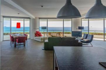 Spacious living room with ocean view, modern furniture, and ample natural light