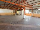 Spacious empty industrial or commercial space with high ceiling and concrete flooring