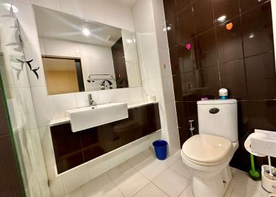 Modern bathroom interior with white fixtures and dark tiles