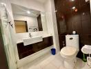 Modern bathroom interior with white fixtures and dark tiles