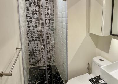 Modern bathroom with patterned shower door and marble floors