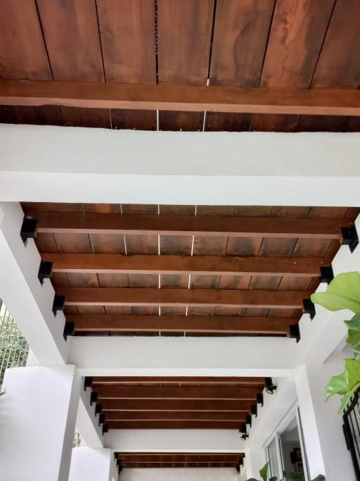 Wooden ceiling design with white beams