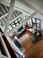 High angle view of a cozy living room with vaulted ceilings and hardwood floors