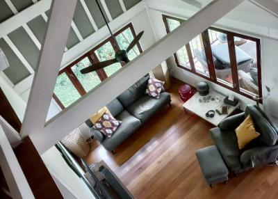 High angle view of a cozy living room with vaulted ceilings and hardwood floors