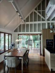 Modern kitchen with wooden floors, high ceiling, and natural view