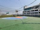 Outdoor basketball court with protective netting in a residential area