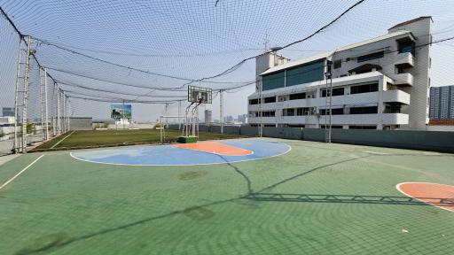 Outdoor basketball court with protective netting in a residential area