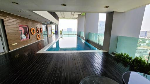 Luxurious rooftop swimming pool with city view and wooden decking