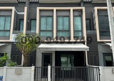 Modern two-story townhouse front exterior with balcony and gate