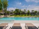 Outdoor swimming pool with loungers and townhouses in the background