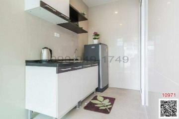 Modern compact kitchen with white cabinets and black countertops