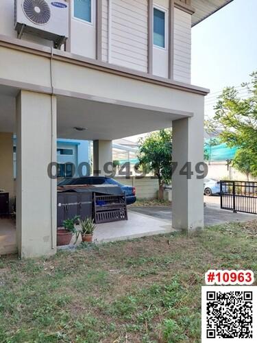 Two-story house exterior view with carport and small garden area