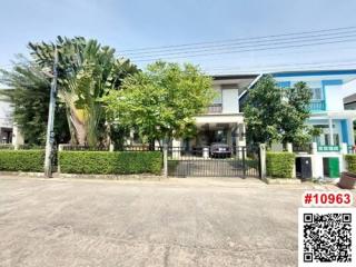 Modern two-story house with a green landscaped front yard and gated entrance