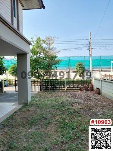 Spacious backyard of a house with a green lawn and trees