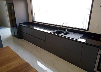 Modern kitchen with sleek black countertops and abundant natural light