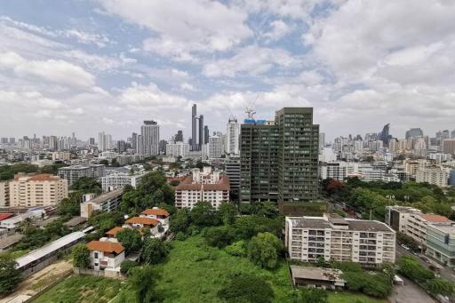 Cityscape view from a residential building showing surrounding architecture and greenery