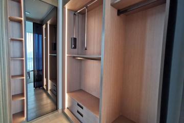 Spacious bedroom closet with open doors showing storage space and drawers