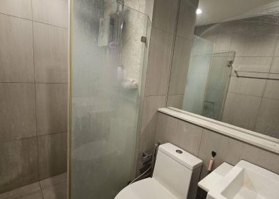 Modern bathroom with glass shower enclosure and marble tiles