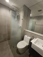 Modern bathroom with glass shower enclosure and marble tiles