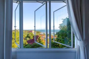 Open bedroom window with a scenic view of the coastline