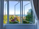 Open bedroom window with a scenic view of the coastline