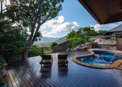 Spacious outdoor deck with swimming pool overlooking scenic mountain views